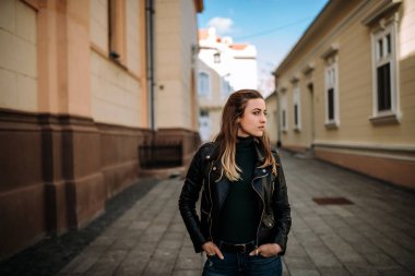 Avrupa şehir sokaklarında yürüyen genç esmer kadın.