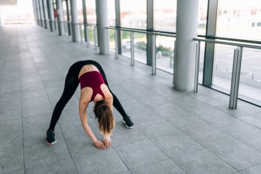 Genç kadının aşağı doğru bakan köpek egzersiz germe yapması