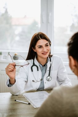Genç doktor ofisinde hastayla konuşuyor
