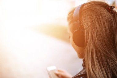 Kulaklıklar açık havada müzik dinlemek genç esmer kadın