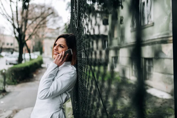 Mujer Joven Usando Teléfono Inteligente Apoyado Valla — Foto de Stock