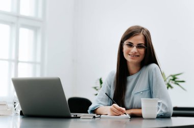 Genç işkadını üstünde laptop parlak Office çalışma