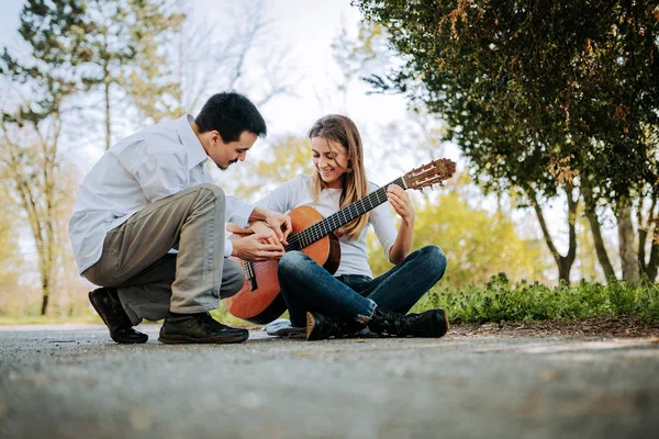 공원에서 기타를 여자를 가르치는 — 스톡 사진