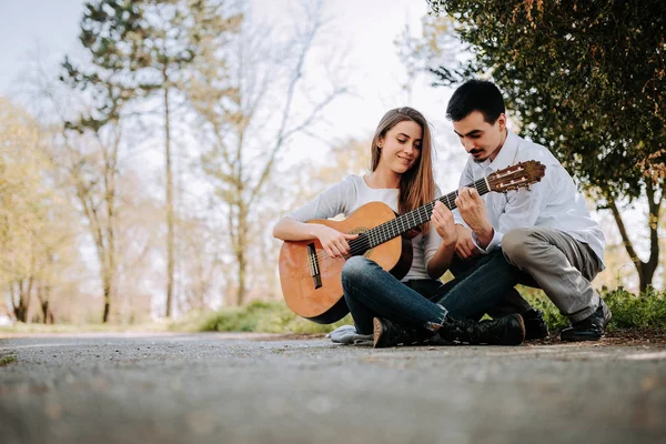 Junger Mann Lehrt Freundin Park Gitarre Spielen — Stockfoto