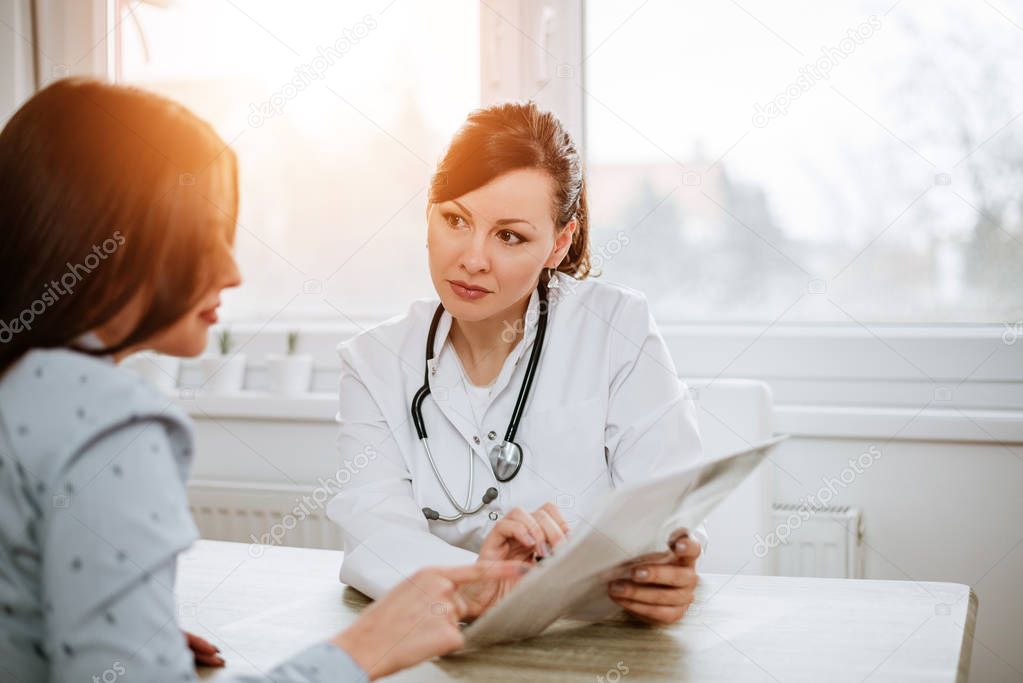 Young doctor talking with patient in office