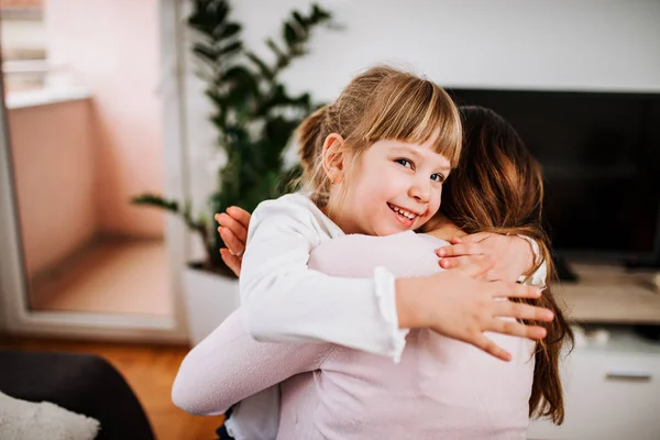 Smiling Blonde Girl Hugging Her Mother Home — Stock Photo, Image