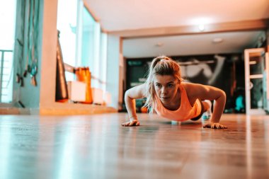 Kararlı genç kadının yapması Push ups.