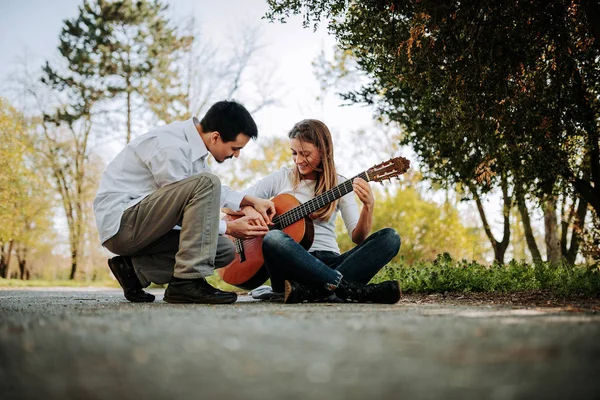Молодий Чоловік Навчає Дівчину Грати Гітарі Парку — стокове фото