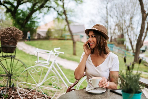 Mujer Sonriente Sentada Jardín Cafetería Usando Teléfono Inteligente —  Fotos de Stock