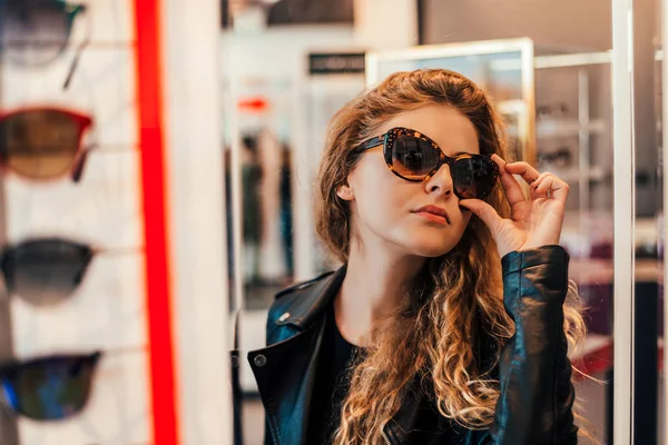 Mujer Joven Eligiendo Nuevas Gafas Sol Tienda Óptica —  Fotos de Stock