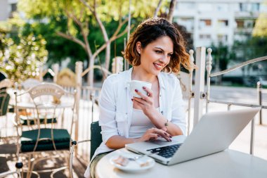 Şehir kafede dizüstü bilgisayar kullanan genç sarışın kadın