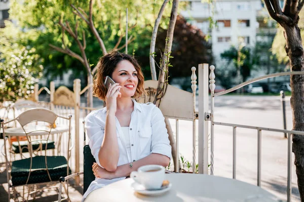 Mujer Joven Hablando Teléfono Inteligente Cafetería Ciudad —  Fotos de Stock