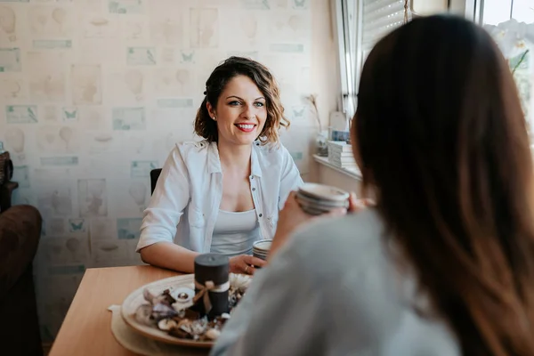 Zwei Glückliche Junge Freundinnen Mit Kaffeetassen Heimischen Wohnzimmer Gespräch — Stockfoto