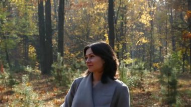 Bir kız parkta sonbaharda yürüyor. 