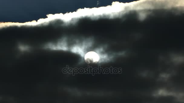 De zon bevindt zich achter de zwarte wolken. Volle maan — Stockvideo