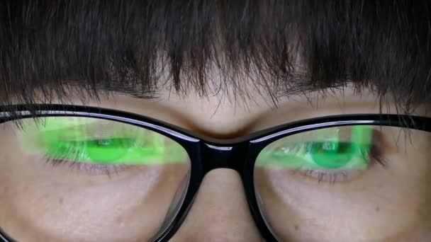 Una ragazza in occhiali guarda il display del computer portatile . — Video Stock