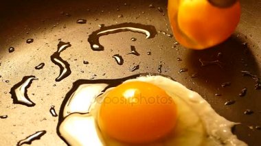 Bir tavada yumurta kızart. Kırık çiğ yumurta