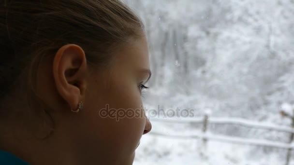 Chica Está Mirando Por Ventana Nieve Que Cae — Vídeos de Stock