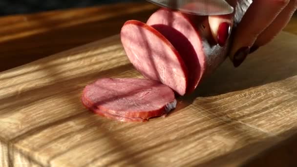 Cortar salchichas en una tabla de cortar. Salchicha de res. Corte con un cuchillo de cocina . — Vídeos de Stock