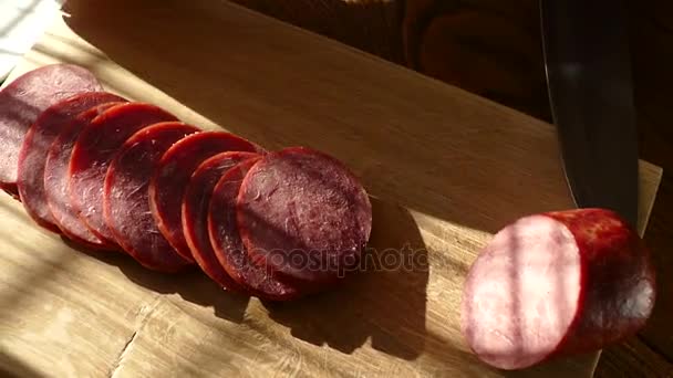 Slicing sausage on a cutting board. Beef sausage. Cut with a kitchen knife. — Stock Video