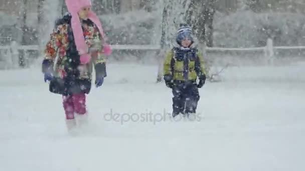 Los Niños Están Caminando Bajo Una Fuerte Nevada Niño Niña — Vídeo de stock