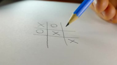 Kağıt üzerinde bir kalemle oynarken Tic Tac Toe.
