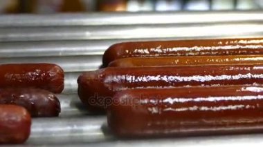 Sosis sosisli sandviç için ısıtılır. Fransız sosisli sandviç hazırlanıyor. Sosis ızgara iplik. Fast food