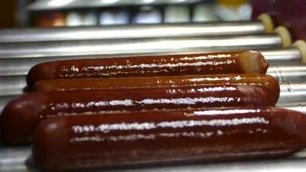 Würstchen werden für Hot Dogs erhitzt. Zubereitung des französischen Hot Dogs. Würstchen auf dem Grill drehen. Fast Food — Stockvideo