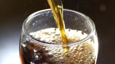 Coca Cola İçecek bir bardak dökülür. Kabarcıklar gazlı içecek.