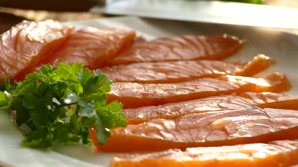 まな板の上の鮭の切り身と皿の上の広がりをカットします おいしい鮭の切り身は スパイスを振りかけています 脂肪のノルウェーの魚 オメガ — ストック動画