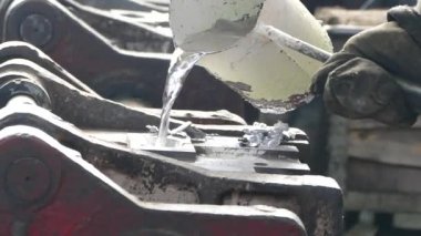 Erimiş alüminyum kalıplara dökülür. Bir kişi dökülen sıvı metal fabrikası.