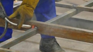 Bir adam bir kaynak makinesi ile çalışır. Fabrikada kaynak çelik yapılar. Dışarı güzel kıvılcımlar