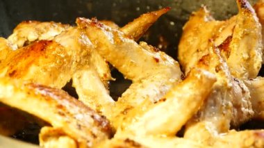 Bir tavada tavuk kanadı yandı. Tavuk yemekten. Bir tava kızgın yağ kaynar.