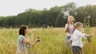 Doğada mutlu bir aile. Anne ve çocuk kabarcıklar üfleme vardır. Bir kız ve bir oğlan annesi ile oynuyorlar. Aile ile kamp. Glade forest yakınındaki. Güneş parlıyor ve yağmur yağıyor.