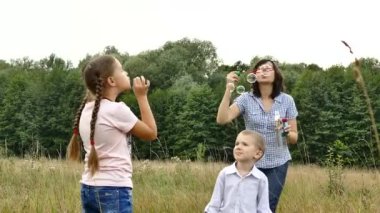 Doğada mutlu bir aile. Anne ve çocuk kabarcıklar üfleme vardır. Bir kız ve bir oğlan annesi ile oynuyorlar. Aile ile kamp. Glade forest yakınındaki. Güneş parlıyor ve yağmur yağıyor.