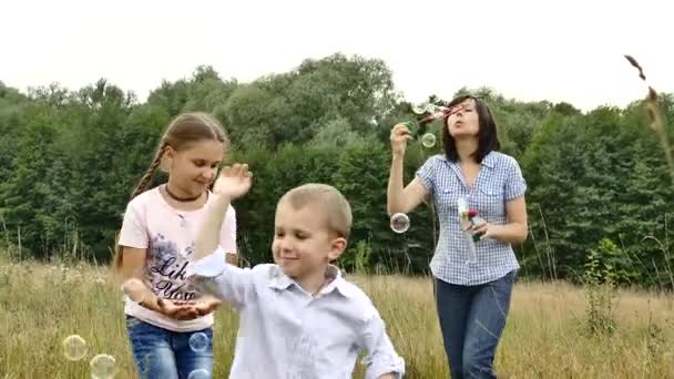 Familia Feliz Jugando Naturaleza Mamá Los Niños Están Soplando Burbujas — Vídeo de stock