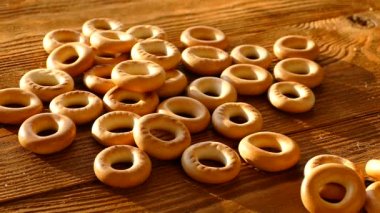 Ekmek simit bir ahşap masa üstüne düşmek. A bohça-in simit masada yatıyor. Unlu Mamüller.