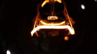 Akkor lamba ile tungsten filaman tel üzerinde wobbles. Işık yanıp söner nedeniyle fakir bir kişi. Elektrik enerjisi odaya kayboldu. Bir ampul ışığı. Ampul yakın çekim.