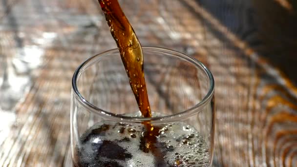 A sweet cola drink is poured into a glass beaker. Beautiful bubbles of carbonated water in a glass. — Stock Video