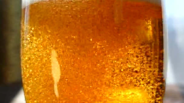 啤酒倒入玻璃杯中 低酒精的黄色饮料 碳酸饮料的美丽气泡 复古餐桌上的一杯泡沫啤酒 — 图库视频影像