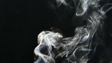 Güzel gri duman yavaş odaya uçar. Siyah bir arka plan üzerinde dumanı. Buhar yükselir. Dokulu sis.