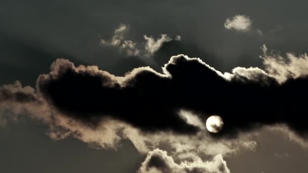 Le soleil cache des nuages et des nuages flottant dans le ciel. Les rayons du soleil se fraient un chemin à travers les nuages noirs .