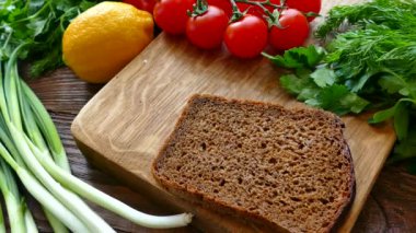 Bir parça siyah ekmeğin üzerine serp. Ekmek ve sebzeli balık kesim masasında. Atıştırmalık votka 