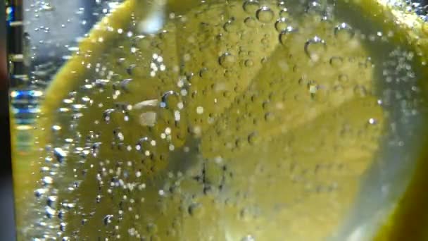 미네랄 스파클링 물에서 신선한 오렌지 과일의 슬라이스 상쾌한 거품으로 칵테일 — 비디오