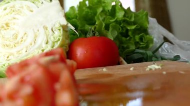 Mutfakta bir kesme tahtası dilimlenmiş domates ve diğer sebzeler. Sağlıklı yemek.