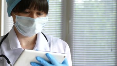 Doktor enjeksiyon için bir şırınga hazırlıyor. Hemşire ilacı bir şırıngada aldı. Hastalığın ilaçlarla tedavi edilmesi. Maske ve şapka takan bir tıp asistanı..