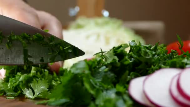 Κοπή μαϊντανό και τα λαχανικά με ένα μαχαίρι σε ένα ξύλο κοπής. — Αρχείο Βίντεο