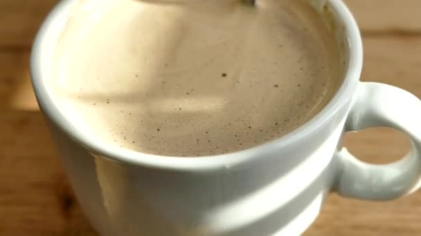 Uma xícara de café com espuma. Libra uma bebida quente matinal com uma colher . — Vídeo de Stock
