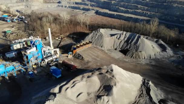 Cantera de granito. Empresa minera de granito piedra. La vista desde la altura de la cantera. Una excavadora está cargando un camión con piedra . — Vídeo de stock