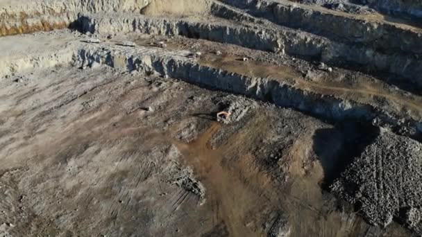 Cantera de granito. Empresa minera de granito piedra. La vista desde la altura de la cantera. Una excavadora está cargando un camión con piedra . — Vídeos de Stock